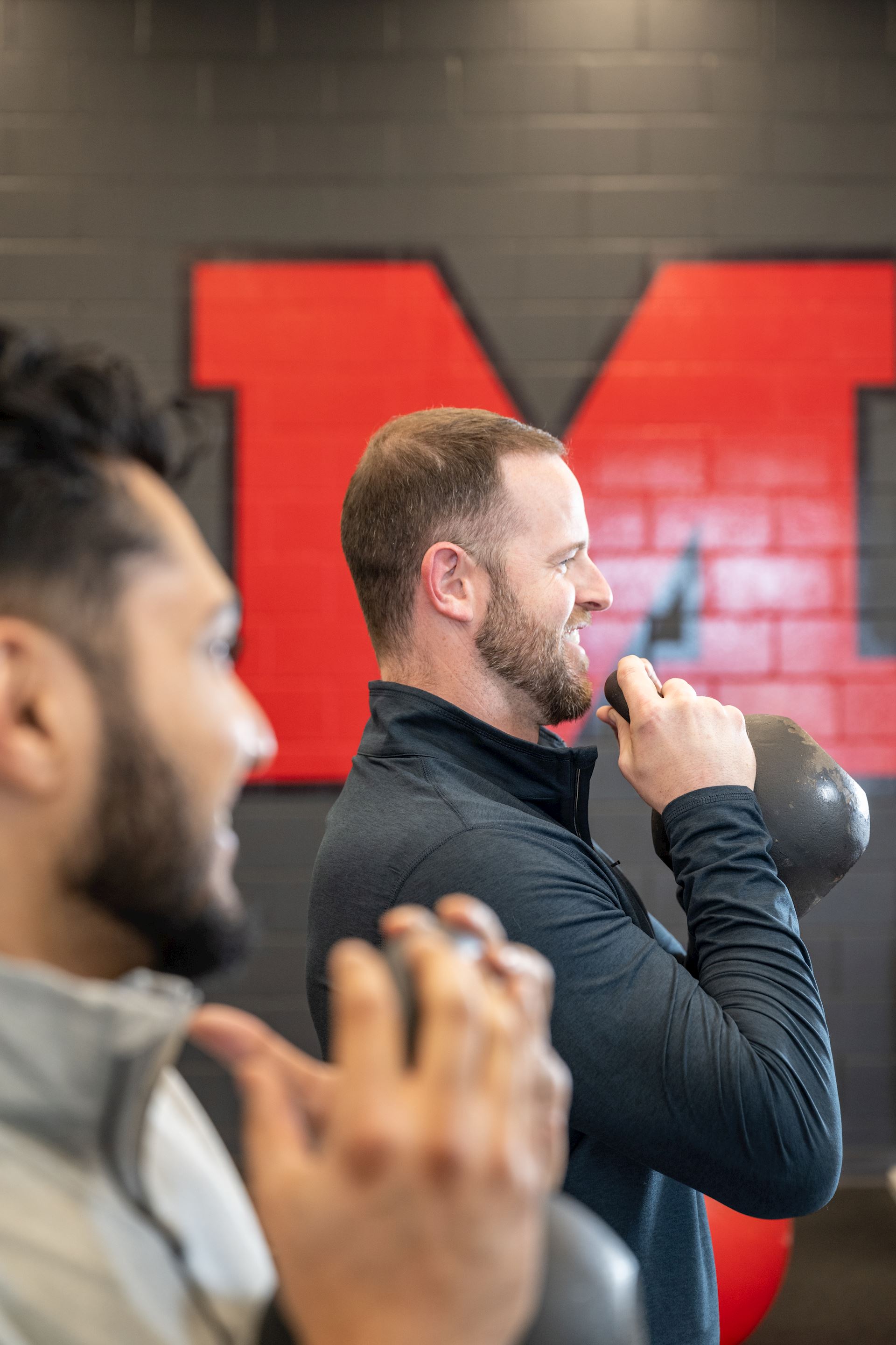 physical therapist demonstrating rehab exercises with kettlebell